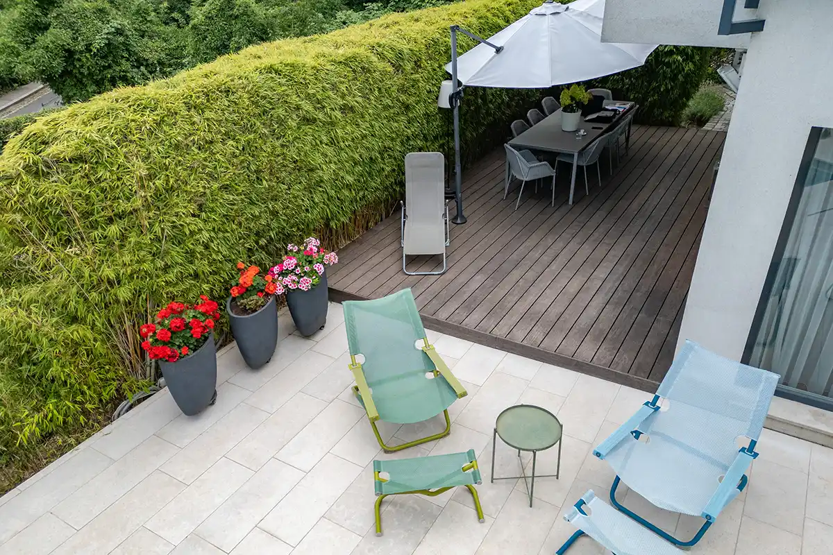 sgd - Professionelle Terrassendeck-Konstruktion Eine Terrasse mit Stühlen und einem Sonnenschirm, ideal für entspannte Stunden im Freien