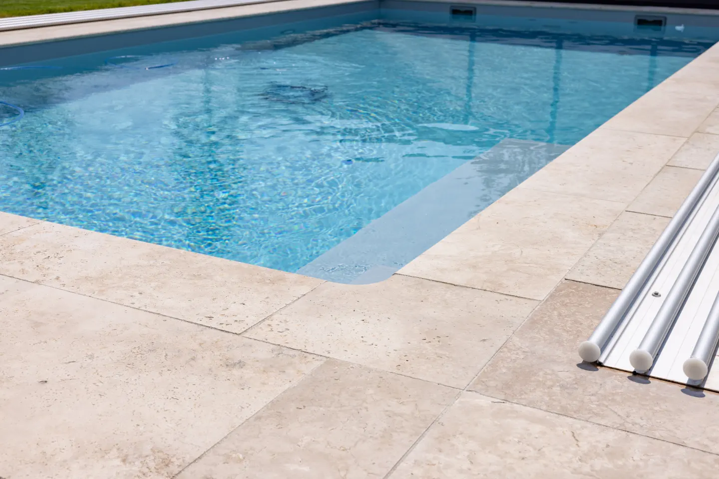 Moderne Poolumrandung und Überdachung – saubere Gestaltung der Wasserzone im Garten.