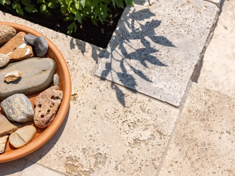 Fachgerechte Verlegung von hellen Natursteinplatten im Garten.