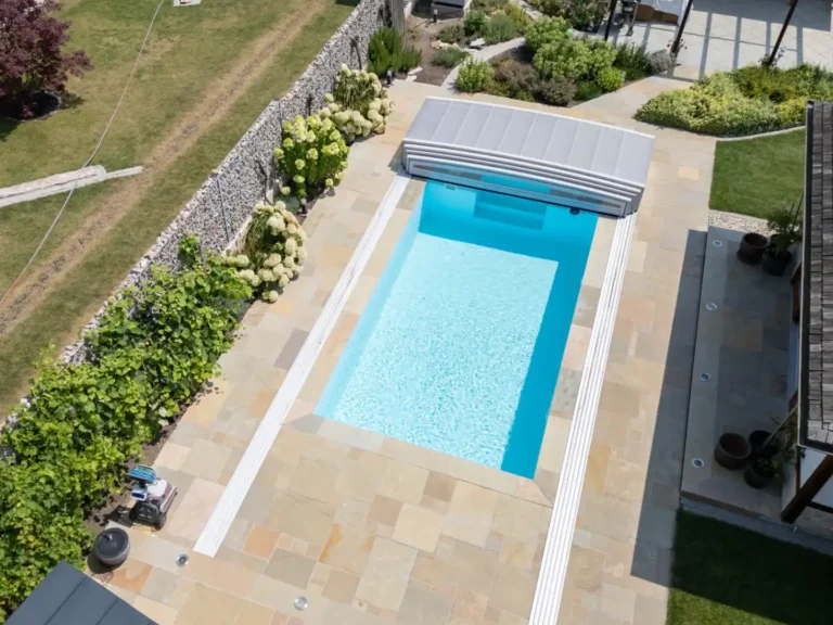 Moderne Poolumrandung aus hellen Natursteinplatten – langlebig und fachgerecht verlegt.